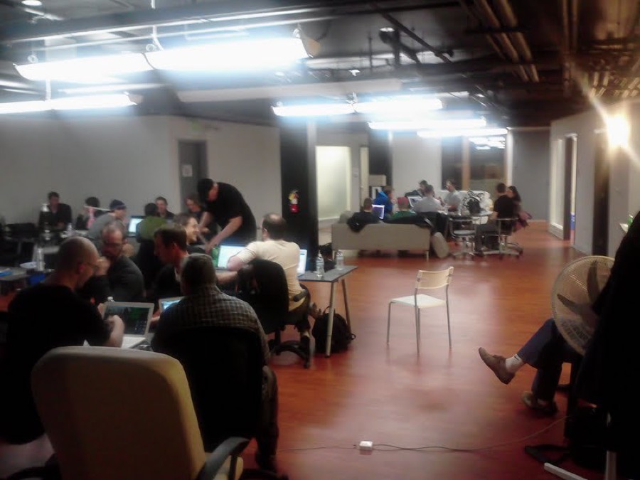 Developers pair-programming at laptops during a Protonight hack session